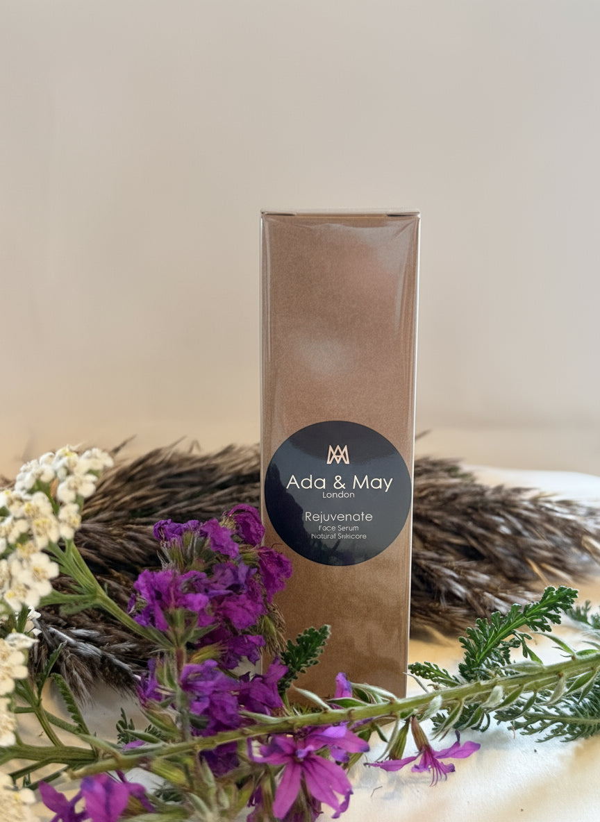 Product packaging with 'Ada & May' branding surrounded by purple flowers and greenery on a neutral background