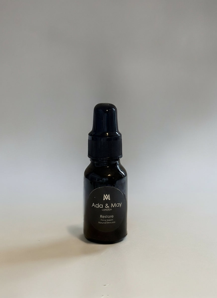 clean image of restore oil Black bottle with a label on a gray background